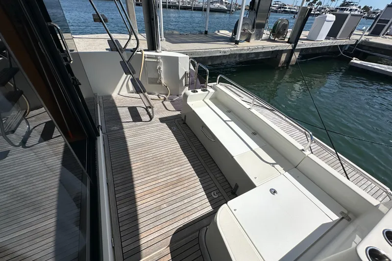 Slide: The Image of 2021 Beneteau Swift Trawler 41 Fly deck with wooden flooring at marina. - 15