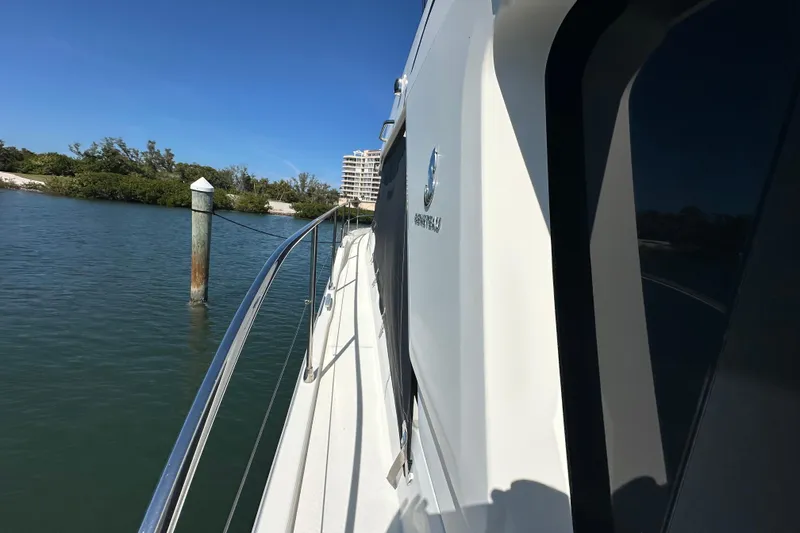 Slide: The Image of 2021 Beneteau Swift Trawler 41 Fly cruising near shoreline, clear blue sky. - 18