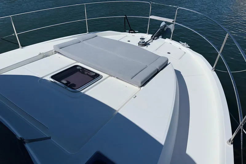 Slide: The Image of 2021 Beneteau Swift Trawler 41 Fly deck with sunpad and railing, on calm water. - 20