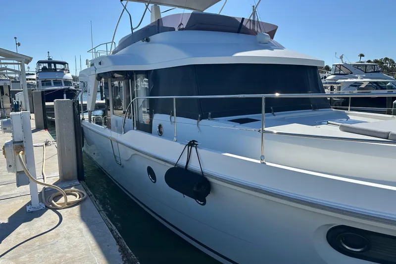 Slide: The Image of 2021 Beneteau Swift Trawler 41 Fly docked at marina under clear blue sky. - 27