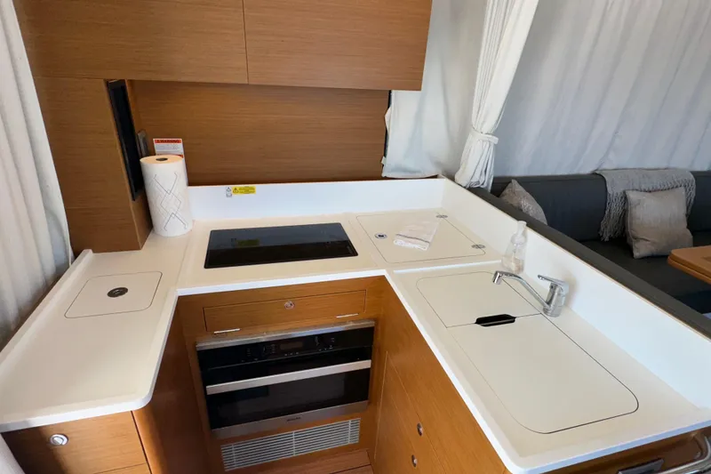 Slide: The Image of Modern kitchen in 2021 Beneteau Swift Trawler 41 Fly yacht, featuring sleek appliances and wood finish. - 31