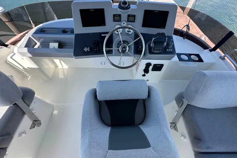 Slide: The Image of Control panel of 2021 Beneteau Swift Trawler 41 Fly with Raymarine displays and steering wheel. - 5