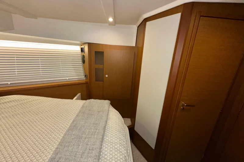 Slide: The Image of Interior cabin of 2021 Beneteau Swift Trawler 41 Fly with wood paneling and bed. - 57