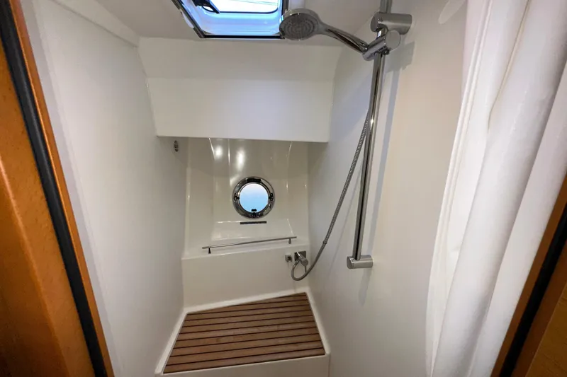 Slide: The Image of Shower area in 2021 Beneteau Swift Trawler 41 Fly with wooden floor and porthole. - 58