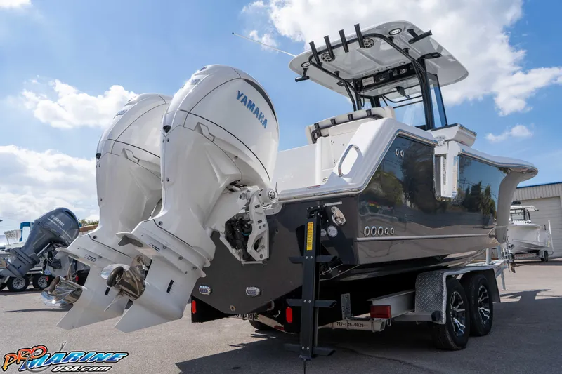 Slide: The Image of 2026 Sea Hunt Gamefish 25 boat with dual Yamaha engines on a trailer. - 11