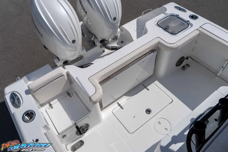 Slide: The Image of 2026 Sea Hunt Gamefish 25 boat interior with Yamaha engines, featuring seating and storage compartments. - 17