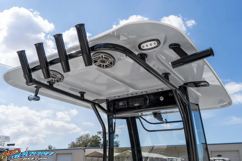 Slide: The Image of 2026 Sea Hunt Gamefish 25 T-top with rod holders and speakers under a blue sky. - 20