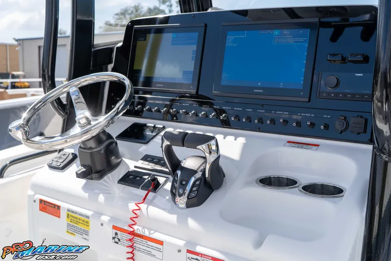Slide: The Image of 2026 Sea Hunt Gamefish 25 boat dashboard with steering wheel and dual Garmin displays. - 22