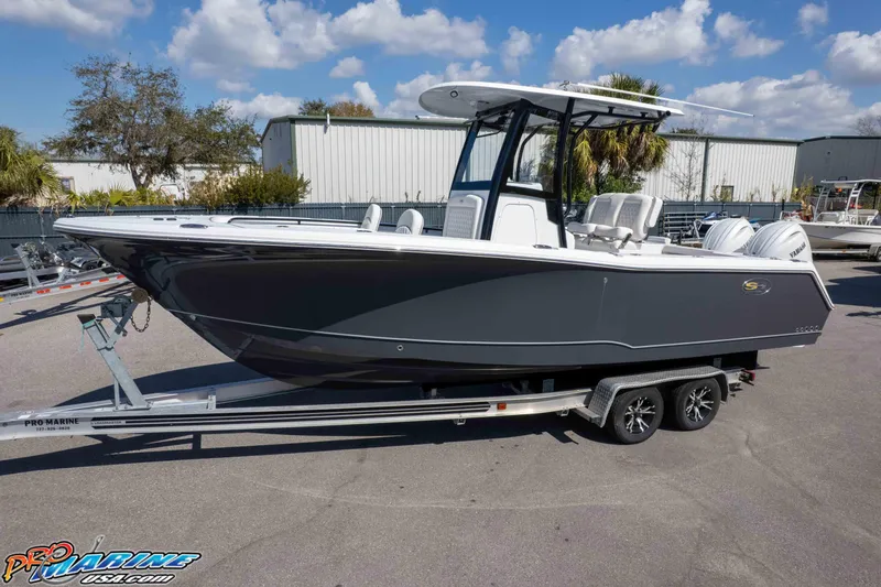 Slide: The Image of 2026 Sea Hunt Gamefish 25 boat on trailer, sleek design, dual engines, sunny day. - 34