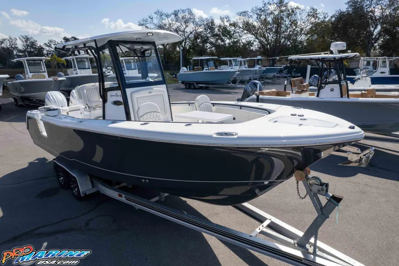 Slide: The Image of 2026 Sea Hunt Gamefish 25 boat on trailer, parked outdoors, surrounded by other boats. - 48