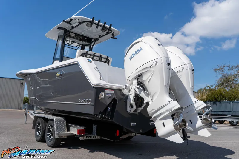 Slide: The Image of 2026 Sea Hunt Gamefish 25 boat with dual Yamaha engines on a trailer. - 8