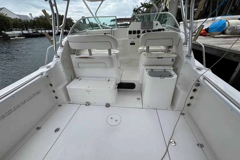 Slide: The Image of 2008 Wellcraft 290 Coastal boat interior with seating and helm, docked by the water. - 2