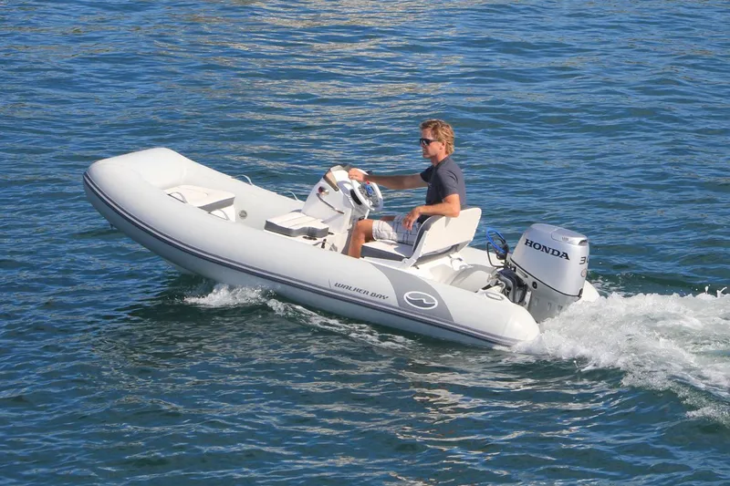 Slide: The Image of Manufacturer Provided Image: 2025 Walker Bay 325 STX Deluxe boat cruising on water with Honda engine. - 10