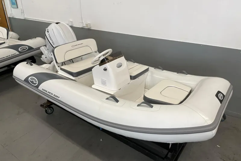 Slide: The Image of 2025 Walker Bay 325 STX Deluxe inflatable boat with Tohatsu engine in showroom. - 6