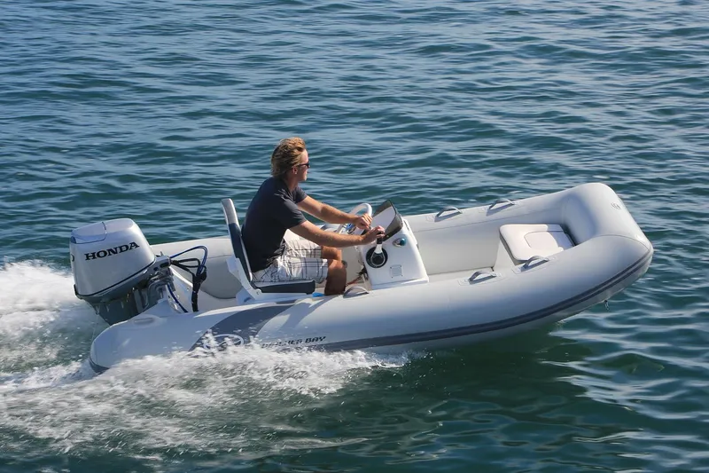 Slide: The Image of Manufacturer Provided Image: 2025 Walker Bay 325 STX Deluxe boat cruising on water with Honda engine. - 8