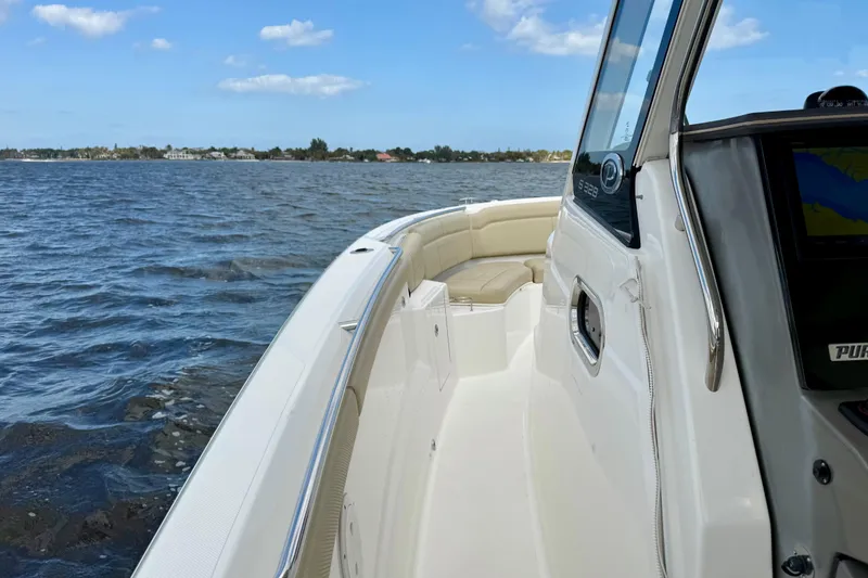 Slide: The Image of 2019 Pursuit S 328 Sport boat cruising on open water under blue sky. - 10
