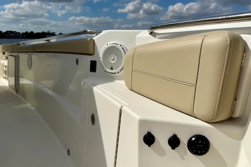 Slide: The Image of 2019 Pursuit S 328 Sport boat interior with beige seating and audio controls. - 11