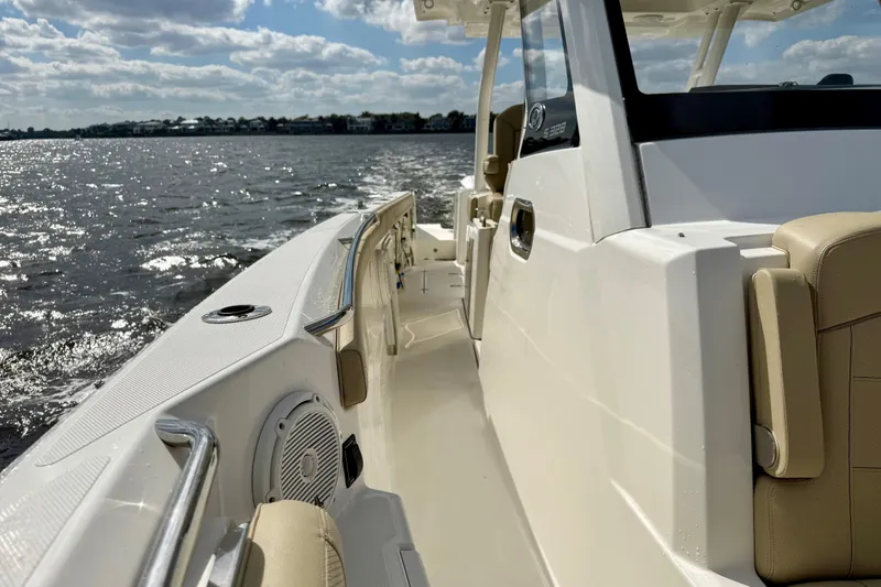Slide: The Image of 2019 Pursuit S 328 Sport boat cruising on a sunny day, showcasing sleek design and comfort. - 12