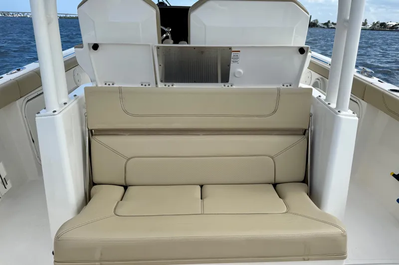 Slide: The Image of 2019 Pursuit S 328 Sport boat with beige seating, ocean backdrop. - 18