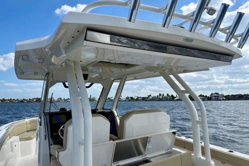 Slide: The Image of 2019 Pursuit S 328 Sport boat on water, featuring helm and seating area. - 20