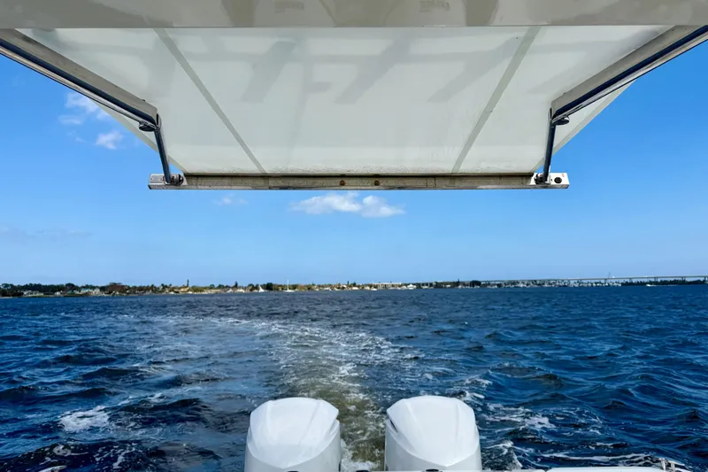 Slide: The Image of 2019 Pursuit S 328 Sport boat cruising on open water under a clear blue sky. - 21