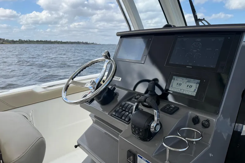 Slide: The Image of 2019 Pursuit S 328 Sport boat dashboard with steering wheel and navigation screens. - 4