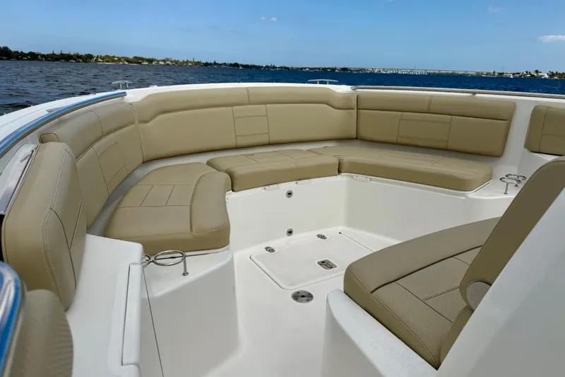 Slide: The Image of 2019 Pursuit S 328 Sport boat with beige seating, cruising on a calm lake. - 6