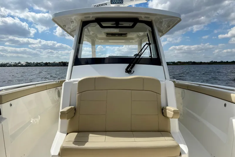 Slide: The Image of 2019 Pursuit S 328 Sport boat interior with beige seating, on a sunny day. - 9