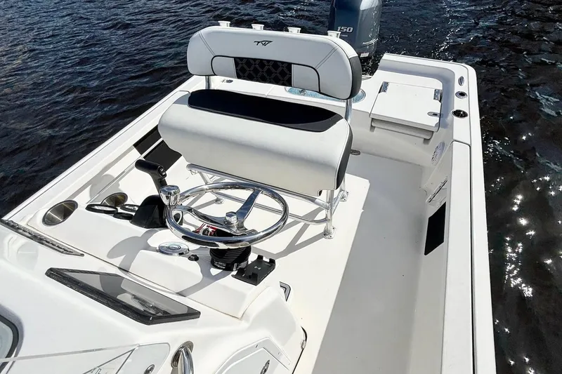 Slide: The Image of 2022 Tidewater 2110 Bay Max boat interior with steering wheel and seating on water. - 10