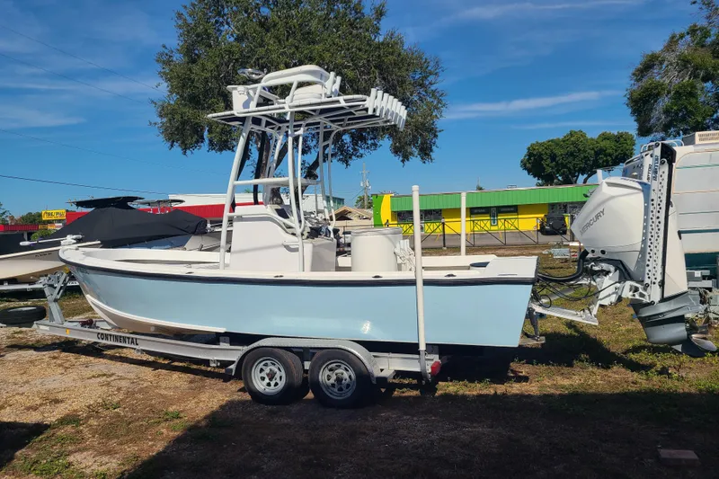 The Image of 1969 Aquasport 222 Center Console boat on trailer, parked outdoors under clear sky. - 0