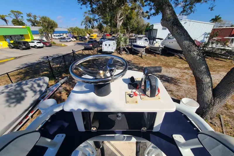 Slide: The Image of 1969 Aquasport 222 Center Console boat steering wheel and controls, parked outdoors. - 14