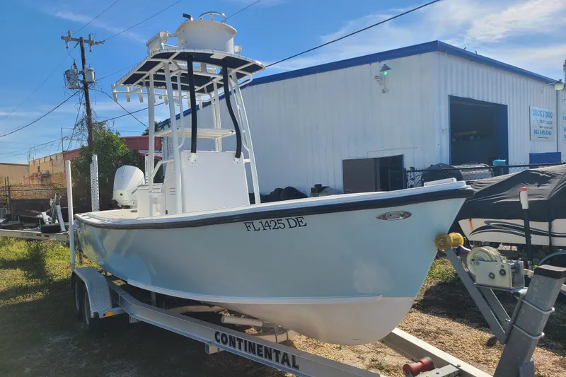 Slide: The Image of 1969 Aquasport 222 Center Console boat on trailer, parked outdoors near a building. - 2