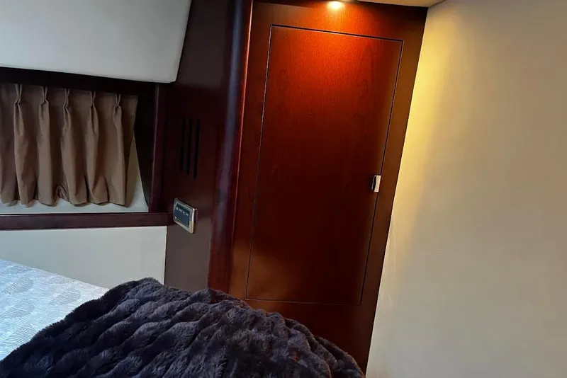 Slide: The Image of Luxurious interior of 2007 Sea Ray 38 Sundancer yacht with wood paneling and cozy bedding. - 11