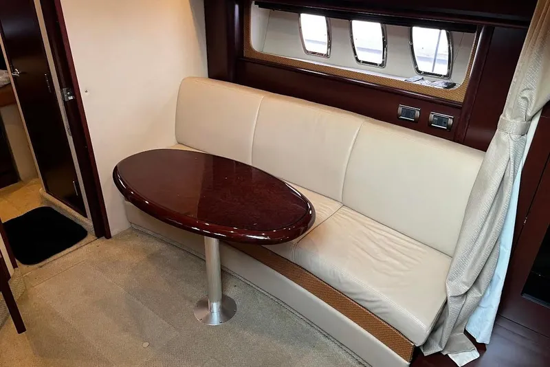 Slide: The Image of Interior of 2007 Sea Ray 38 Sundancer with cream sofa and oval wooden table. - 18