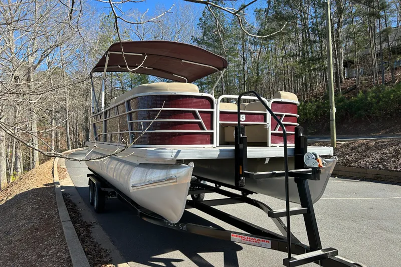 The Image of 2022 Godfrey Sweetwater 2286 C pontoon boat on trailer in wooded area. - 1