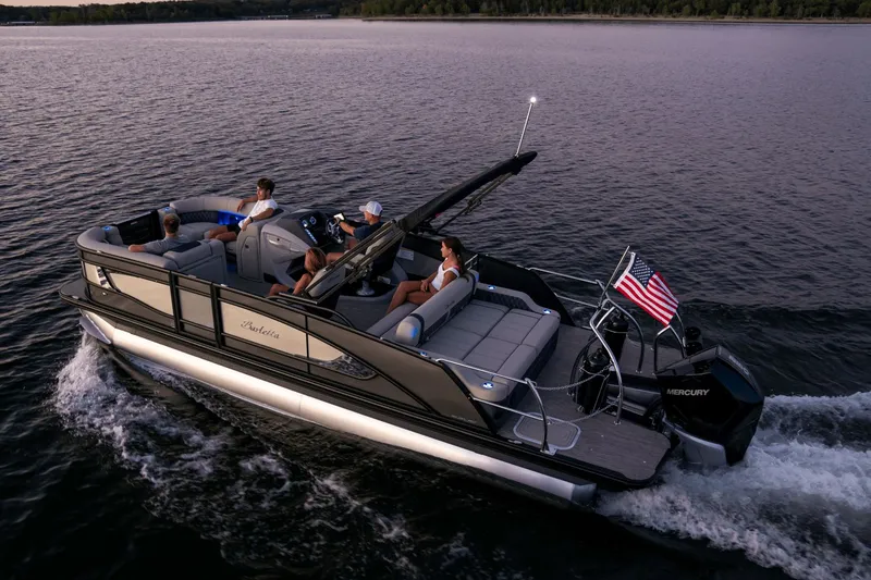 Slide: The Image of Barletta LUSSO 25 UC 2026 pontoon boat cruising on calm water at sunset. - 2