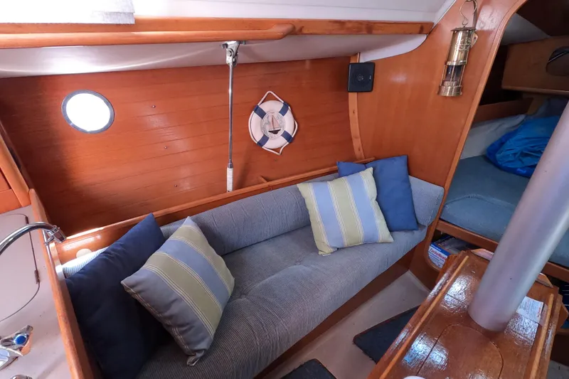 Slide: The Image of Cozy interior of 1990 Beneteau First 285 sailboat with cushions and wooden finish. - 12