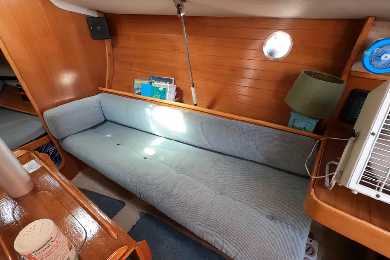 Slide: The Image of Interior of 1990 Beneteau First 285 sailboat with cozy seating and wooden paneling. - 13