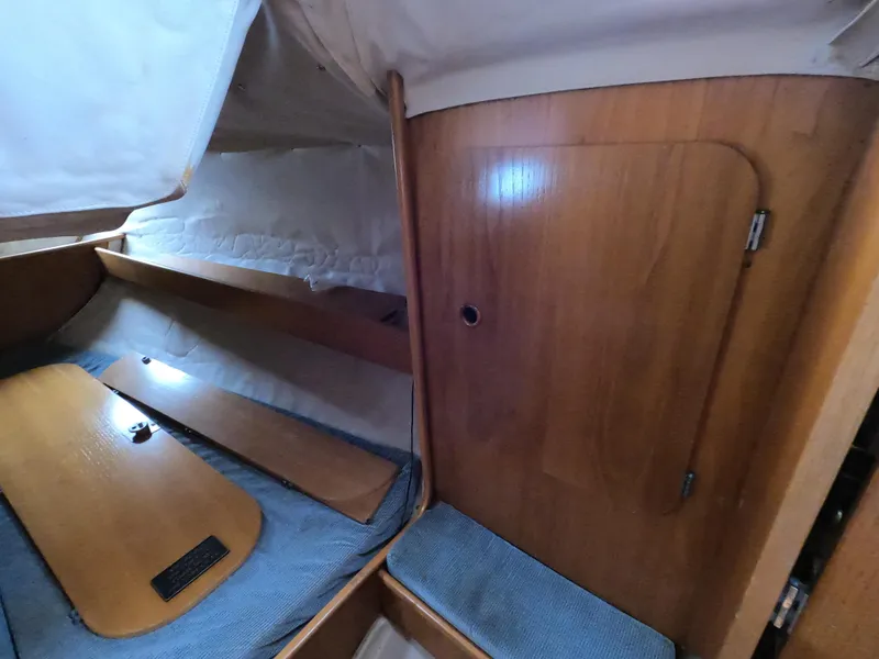 Slide: The Image of Interior of a 1990 Beneteau First 285 yacht, featuring wood finish. - 16