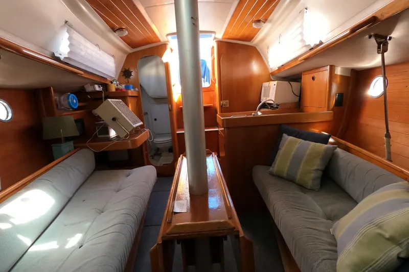 Slide: The Image of Interior of a 1990 Beneteau First 285 sailboat with cozy seating and wooden finishes. - 26
