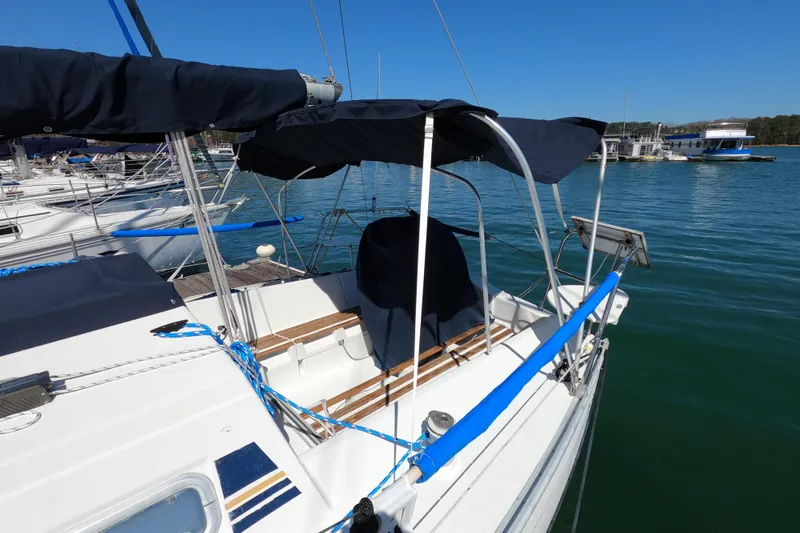 Slide: The Image of 1990 Beneteau First 285 sailboat docked in marina, featuring blue covers and clear skies. - 3