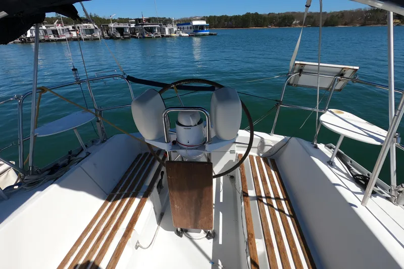 Slide: The Image of Cockpit of 1990 Beneteau First 285 sailboat with wooden seating and steering wheel. - 7