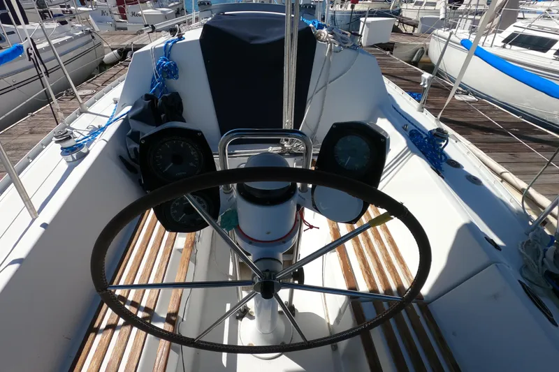 Slide: The Image of Cockpit of 1990 Beneteau First 285 sailboat with steering wheel and navigation instruments. - 8