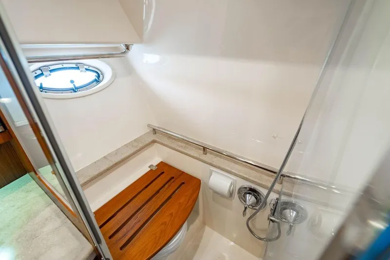 Slide: The Image of 2013 Tiara Yachts 3600 Coronet bathroom with wooden seat and porthole window. - 30