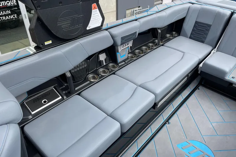 Slide: The Image of 2024 Malibu Wakesetter 26 LSV interior with gray seating and cup holders. - 8