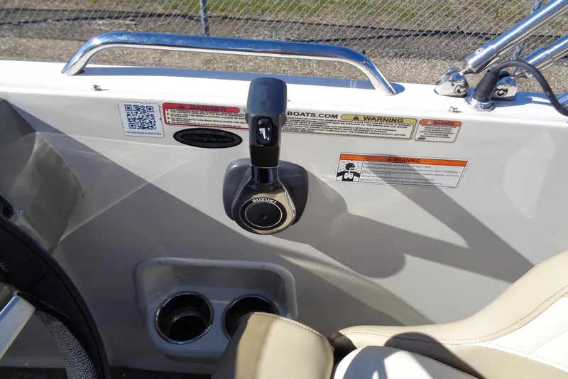 Slide: The Image of 2016 Stingray 192 SC boat control panel with Suzuki throttle and warning labels. - 10