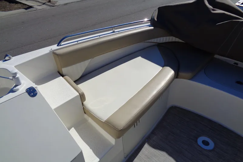 Slide: The Image of 2016 Stingray 192 SC boat interior with beige seating and storage compartments. - 18