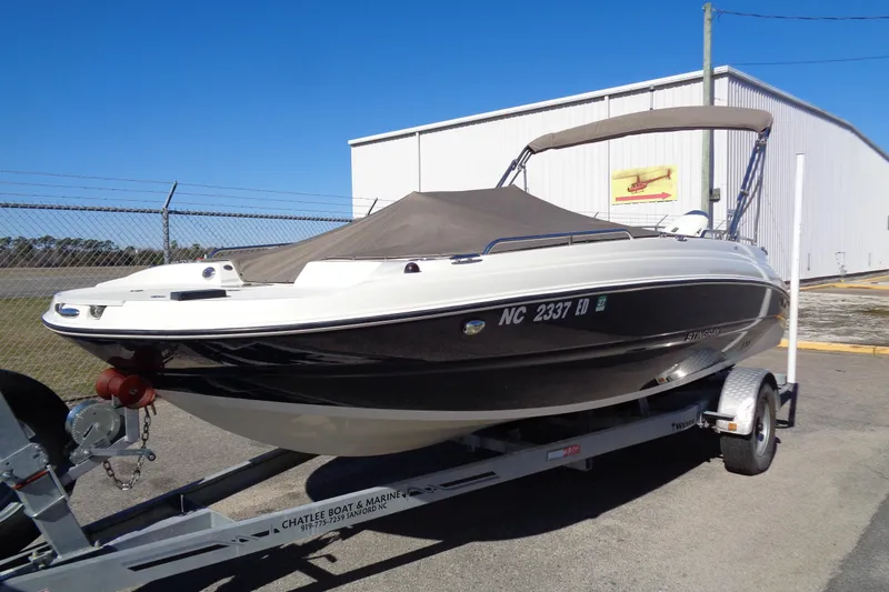 Slide: The Image of 2016 Stingray 192 SC boat on trailer, parked outdoors under clear blue sky. - 2