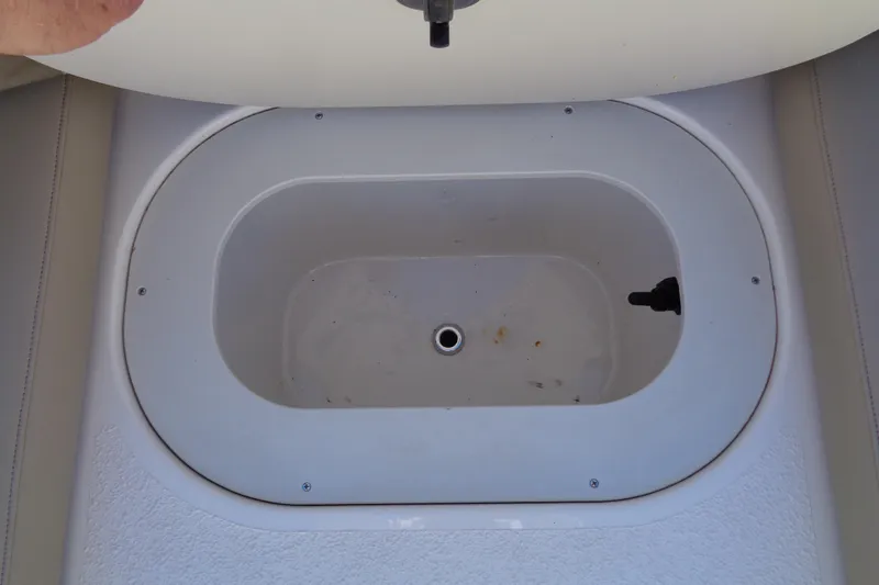 Slide: The Image of 2016 Stingray 192 SC boat storage compartment, open lid, white interior. - 21