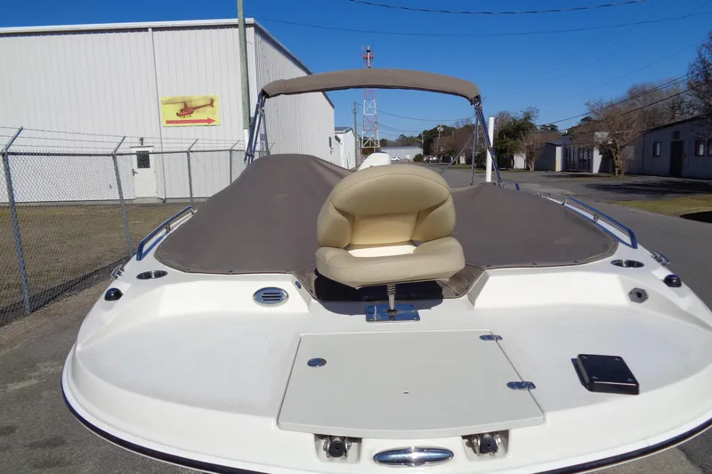 Slide: The Image of 2016 Stingray 192 SC boat with beige seating and cover, parked outdoors. - 25